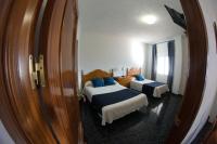 a bedroom with two beds and a large mirror at Hostal Caminito del Rey in Alora