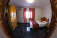 a small bedroom with a bed and a window at Hostal Caminito del Rey in Alora