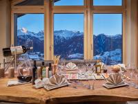 una mesa con copas de vino y vistas a las montañas en Hotel Tirol Fiss 4Sterne Superior, en Fiss