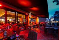 ランゲオークにあるNordseehotel Krögerのテーブルと椅子、座り人が座るレストランです。