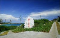 a white stone with red writing on it next to a body of water at Dreamily Fish B&amp;B in Magong