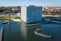 un barco en el agua al lado de un edificio alto en Melia Ria Hotel &amp; Spa, en Aveiro