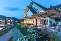 Un patio con mesas, sillas y sombrillas. en Hotel Kompas, en Bled