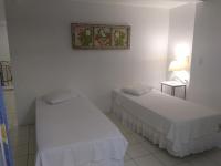 a room with two beds and a picture on the wall at Pousada Casa do Catavento in Búzios