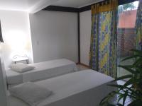 a room with two beds and a window at Pousada Casa do Catavento in Búzios