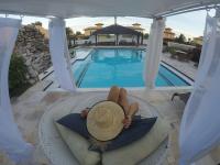 a woman laying on a chair next to a pool at Pousada Casa do Catavento in Búzios