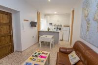 a living room with a couch and a kitchen at Multi Apartamentos La Kasbah in Jerez de la Frontera