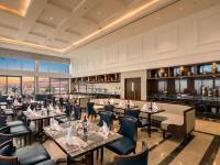 een restaurant met tafels en stoelen en een bar bij Altara Suites Da Nang by AHG in Da Nang