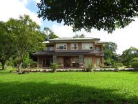 a house with a green lawn in front of it at Seasons Inn in Jiaoxi