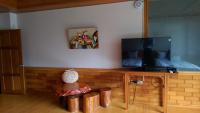 a living room with a television on a wooden stand at Seasons Inn in Jiaoxi