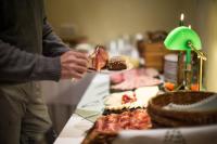 a person holding a plate of food on a table at Wüllner's Landgasthof in Schmallenberg