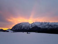 a snow covered mountain with a rainbow in the sky at Nina´s Appartement Bad Mitterndorf in Bad Mitterndorf