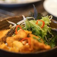 a bowl of food with vegetables on a table at Hotel de l'Opera Hanoi - MGallery in Hanoi