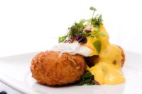 een bord met een donut met kaas en een salade bij The Hermitage Hotel - OCEANA COLLECTION in Bournemouth