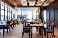 a restaurant with tables and chairs and large windows at Hotel Clover Asoke - SHA Extra Plus in Bangkok