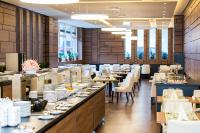 ヘーヴィーズにあるBonvital Hotel Hévíz Superior Adults Onlyのテーブルと椅子、ビュッフェのあるダイニングルーム