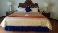 a large bed in a hotel room with two lamps at Ecotel Quinta Regia in Valladolid