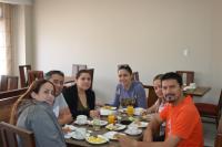 Un grupo de personas sentadas alrededor de una mesa comiendo en Hotel San Agustin Plaza, en Latacunga