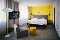 a hotel room with a bed and a chair at Vienna House Easy by Wyndham Bad Oeynhausen in Bad Oeynhausen