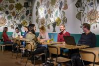 a group of people sitting at tables in a restaurant at Stayokay Hostel Amsterdam Vondelpark in Amsterdam