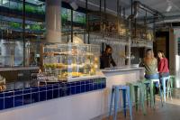 a group of people standing at a counter in a restaurant at Stayokay Hostel Amsterdam Vondelpark in Amsterdam