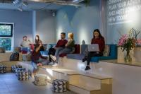 a group of people sitting on couches in a waiting room at Stayokay Hostel Amsterdam Vondelpark in Amsterdam