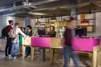 a group of people standing at tables in a store at Stayokay Hostel Amsterdam Vondelpark in Amsterdam