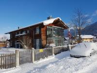 a house with a car parked in the snow at Mittenwald-Ferien in Mittenwald
