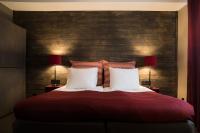 a bedroom with a large red bed with two lamps at Hotell Nordic in Norrköping