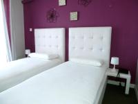 two white beds in a room with purple walls at Hotel Bleu Azur in Argelès-sur-Mer