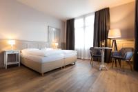 Un dormitorio con una cama y dos sillas y una ventana. en Hotel Emmental, en Thun