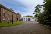 una entrada frente a un gran edificio de ladrillo en Quorn Country Hotel Leicester, en Loughborough