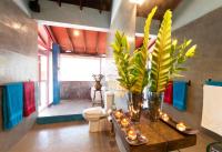 a bathroom with a toilet and vases with flowers and candles at Dickman Resort "The Boutique Hotel" in Negombo