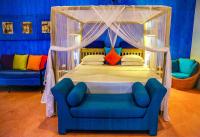 a bedroom with a canopy bed and a blue chair at Dickman Resort "The Boutique Hotel" in Negombo