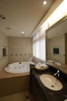 a bathroom with a tub and a sink and a mirror at Jingan Classic Inn in Zhonghe