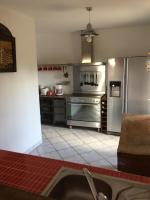 a kitchen with stainless steel appliances and a tile floor at Les Ecuries in Saint-Maurice-en-Cotentin