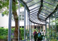 a group of people walking inside of a glass building at Stayokay Hostel Amsterdam Vondelpark in Amsterdam
