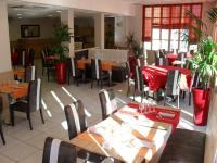 a dining room with tables and chairs in a restaurant at KYRIAD ORANGE Centre Ville - HOTEL RESTAURANT BAR - Galerie d'Art des Princes - Provence Alpes Côte d'Azur - France - Proche A7-A9 - exit21- Châteauneuf-du-Pape Avignon Bollene Nimes Valence - 24h-24h in Orange