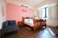 a bedroom with a bed and a chair at Dear B&amp;B in Hualien City