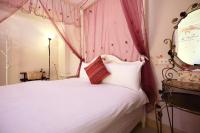a bedroom with a pink canopy bed with pillows at Dear B&amp;B in Hualien City
