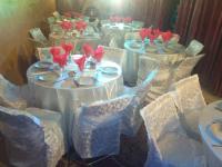 a group of white tables with red flowers on them at Riad Le Lieu in Tiznit