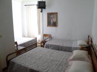 Una habitación de hotel con tres camas y un televisor. en Rustico &amp; Singelo - Hotelaria e Restauração, Lda, en Vila Real