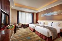 a hotel room with two beds and a flat screen tv at Beijing Hotel Minsk in Minsk