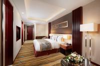 a hotel room with a bed and a table with flowers at Beijing Hotel Minsk in Minsk