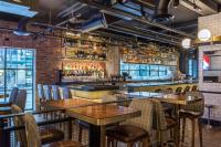 a restaurant with tables and chairs and a bar at Hotel Theodore Seattle Downtown, Tapestry by Hilton in Seattle