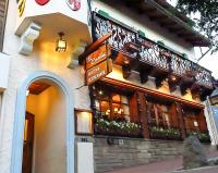 Un edificio con un cartel al costado. en Hostería Suiza - Ex Casita Suiza, en San Carlos de Bariloche