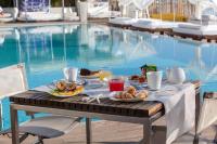una mesa con desayuno junto a una piscina en Vistamare Suite, en Lido di Savio