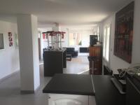 a kitchen and living room with a black counter top at Le Gîte du DAB in La Cadière-dʼAzur