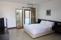 Un dormitorio con una gran cama blanca y un televisor. en Metha Palace, en Sakon Nakhon
