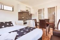a bedroom with a bed and a kitchen with a table at Lorne Foreshore Caravan Park in Lorne